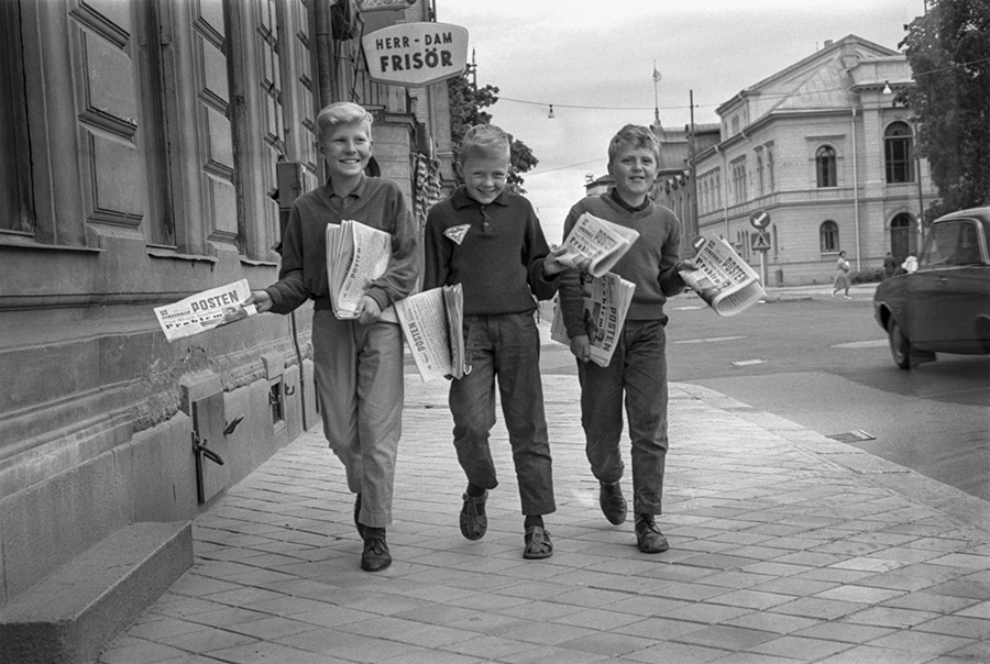 Tre barn går och bär på tidningen Sundsvalls Posten.
