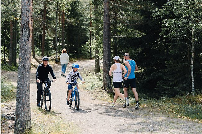 Alttext: Personer som cyklar och löper i motionsspåret Fotograf: Madeleine Englund Bildtext: Personer som cyklar och löper i motionsspåret